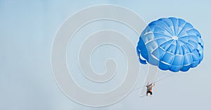 Man flying in the sky on a parachute.