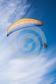 Man flying yellow and blue parasail