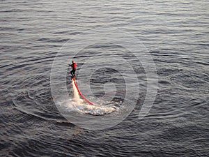 A man is flysurfing at sea. Fly board rider practices flyboard