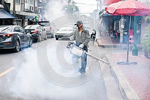 Man fogging to eliminate mosquito on the street