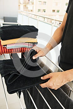 Man folding clothes on a drying rack
