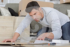 man following instructions to build furniture