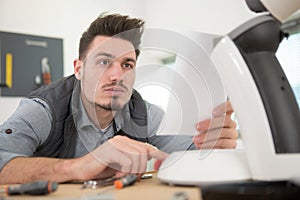 man following instructions to programme electrical appliance