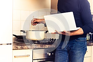 Man following recipe on his laptop computer