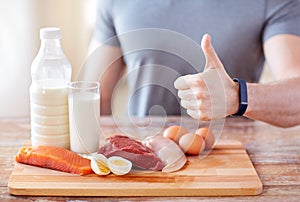 Man with food rich in protein showing thumbs up