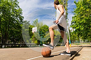 Man with Foot on Basketball Looking Towards Basket