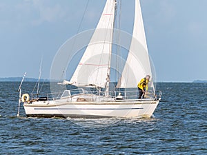 Man on foredeck of sailboat sailing on IJsselmeer lake, Netherlands
