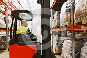 Man on forklift loading cargo at warehouse