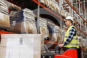 Man on forklift loading cargo at warehouse