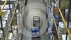 Man on forklift transporting barrels in warehouse