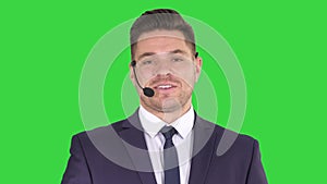 Man in formal clother with a headset presenting something on a Green Screen, Chroma Key.