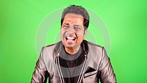 Man in formal suit laughing heartily against green screen background suitable for keying and composites