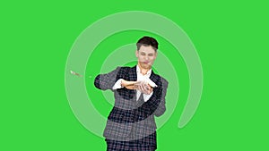 Man in formal suit walking in and throwing money in the air on a Green Screen, Chroma Key.