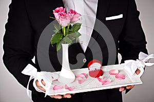 Man in formal wear with engagement ring and flowers