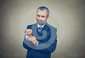 Man in formal wear fastens cufflinks, the buttons of his shirt sleeve