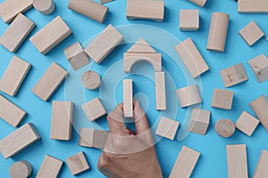 man forming a house with wooden building blocks