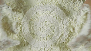 A man forms the dough on a flour-sprinkled surface and kneads it with his hands. The cook grinds flour and butter. The