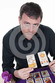 Man Fortune teller using tarot cards on purple table