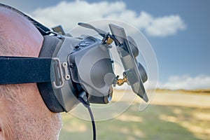 Man with FPV HD goggles, piloting racing drone