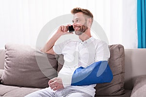 Man With Fractured Hand Talking On Mobile Phone photo