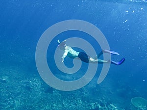 Man freediving in a sea over coral reef