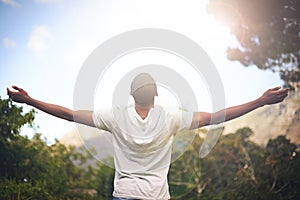 Man, freedom and arms stretched, happiness and appreciate nature in sunlight. Black male person, outdoors and lensflare