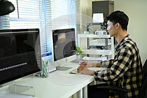 A man freelance editing video on computer with professional program at workspace