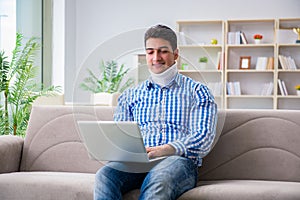 The man freelancer in a cervical collar neck brace working from home