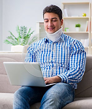Man freelancer in a cervical collar neck brace working from home