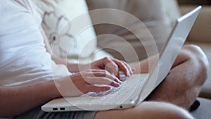 Man freelancer working on laptop at home-office. Close up of hands typing on keyboard. Businessman writing business