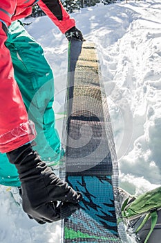 Man freerider installs glue camus on skis, in snow wild mountains