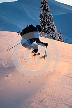 Man freerider sliding down snow-covered slopes on fresh powder snow