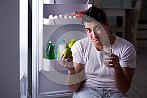 The man at the fridge eating at night