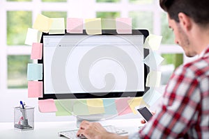 Man front of monitor with lot of sticky notes