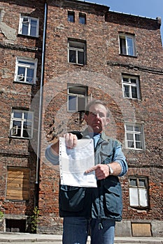 Man in front of ruined house