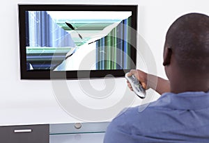 Man In Front Of Television Showing Distorted Screen