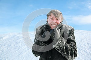 Man froze and hides head in collar of overcoat