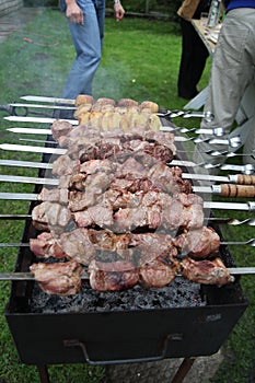 Man is frying meet in garden. Food on skewer, grill, barbecue