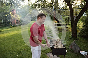 Man is frying meet in garden. Food, skewer, grill, barbecue