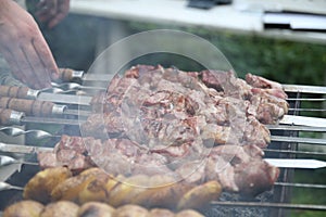 Man is frying meet in garden. Food on skewer, grill, barbecue