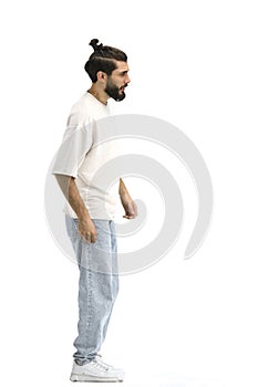 A man, full-length, on a white background, looks into the distance