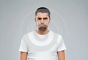 Man with funny angry face over gray background