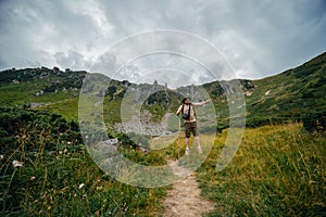 A man funny bounces, jumps, has fun, on the path leading to the top of Mount Spitsy, Carpathian Mountains, nature of Ukraine.