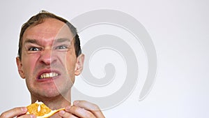 Man Funny eats an orange on a white background