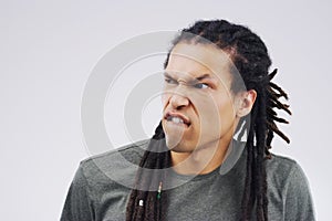 Man, funny face and goofy expression on mockup space against a white studio background. Young male person or model with