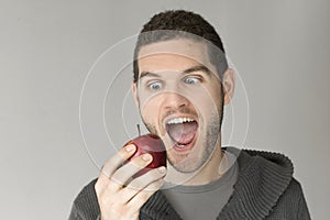 Man with funny face looking at an apple