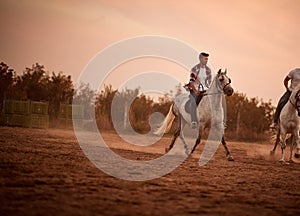 Man on galloping horse at sunset