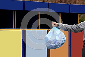 Man with garbage bag at recycling point outdoors, closeup