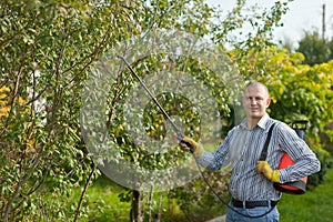 Man with garden spray in orchard