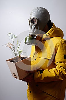 A man in a gas mask with a flower in his hand, isolated on a white background. covid-19 virus